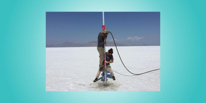 Two people operate a coring device while extracting cores from the Bonneville Salt Flats